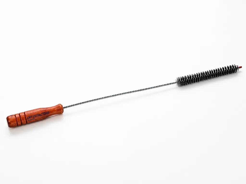 The Lint Extractor brush — varnished wooden handle stamped Lint Extractors Made in USA, long twisted-wire shaft and black bristle head